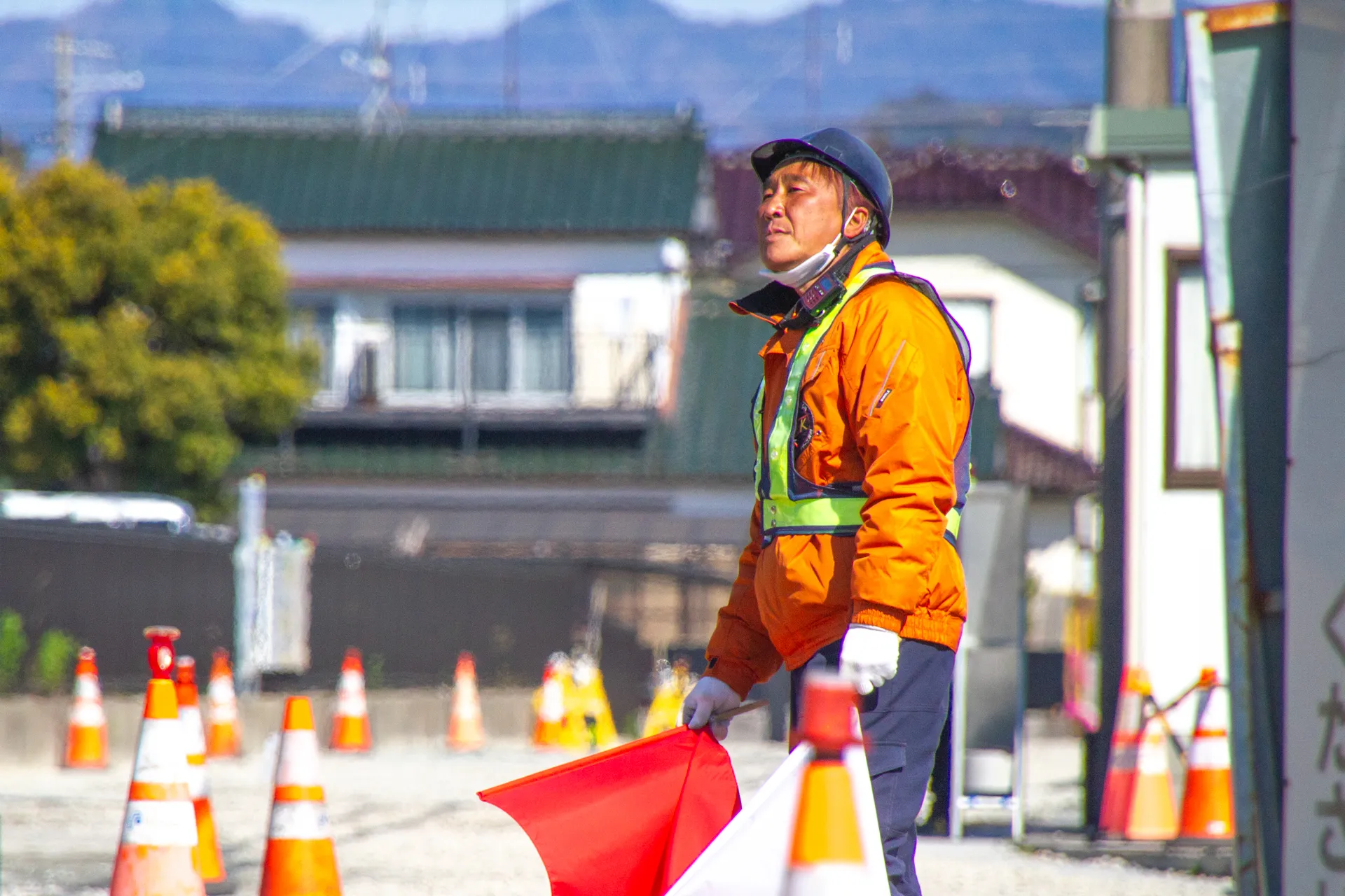 工事中の重機の周りの安全確保をしている警備員